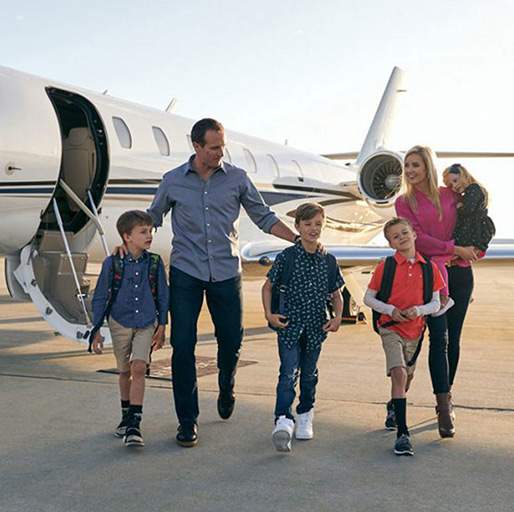 Family of six boarding private jet on tarmac