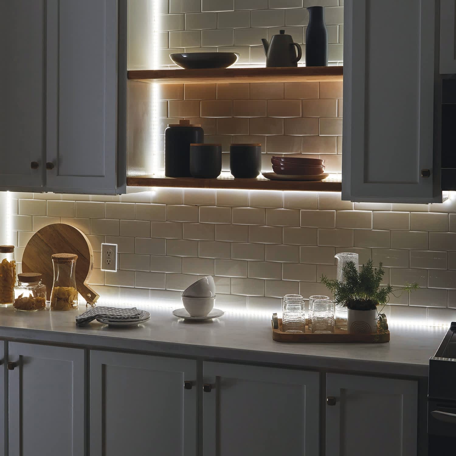 Bright LED strip lighting under kitchen cabinets illuminating the counter