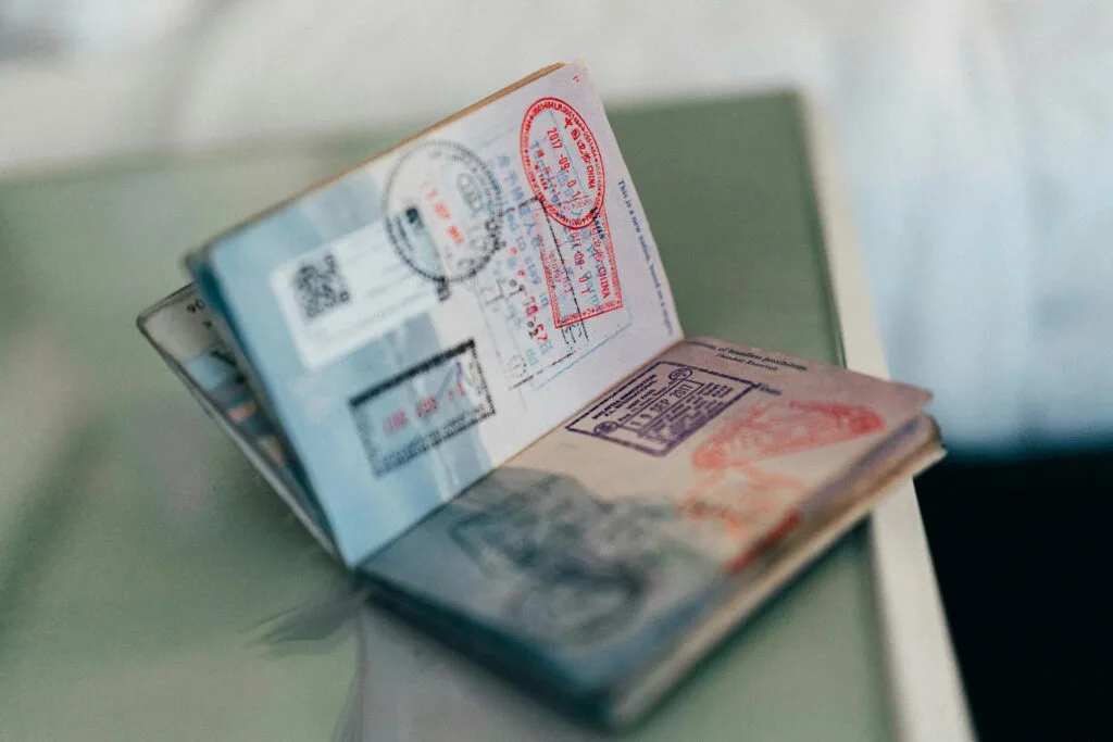 Паспорт і офіційні проїзні документи на столі, що представляють процес подачі візи до Польщі