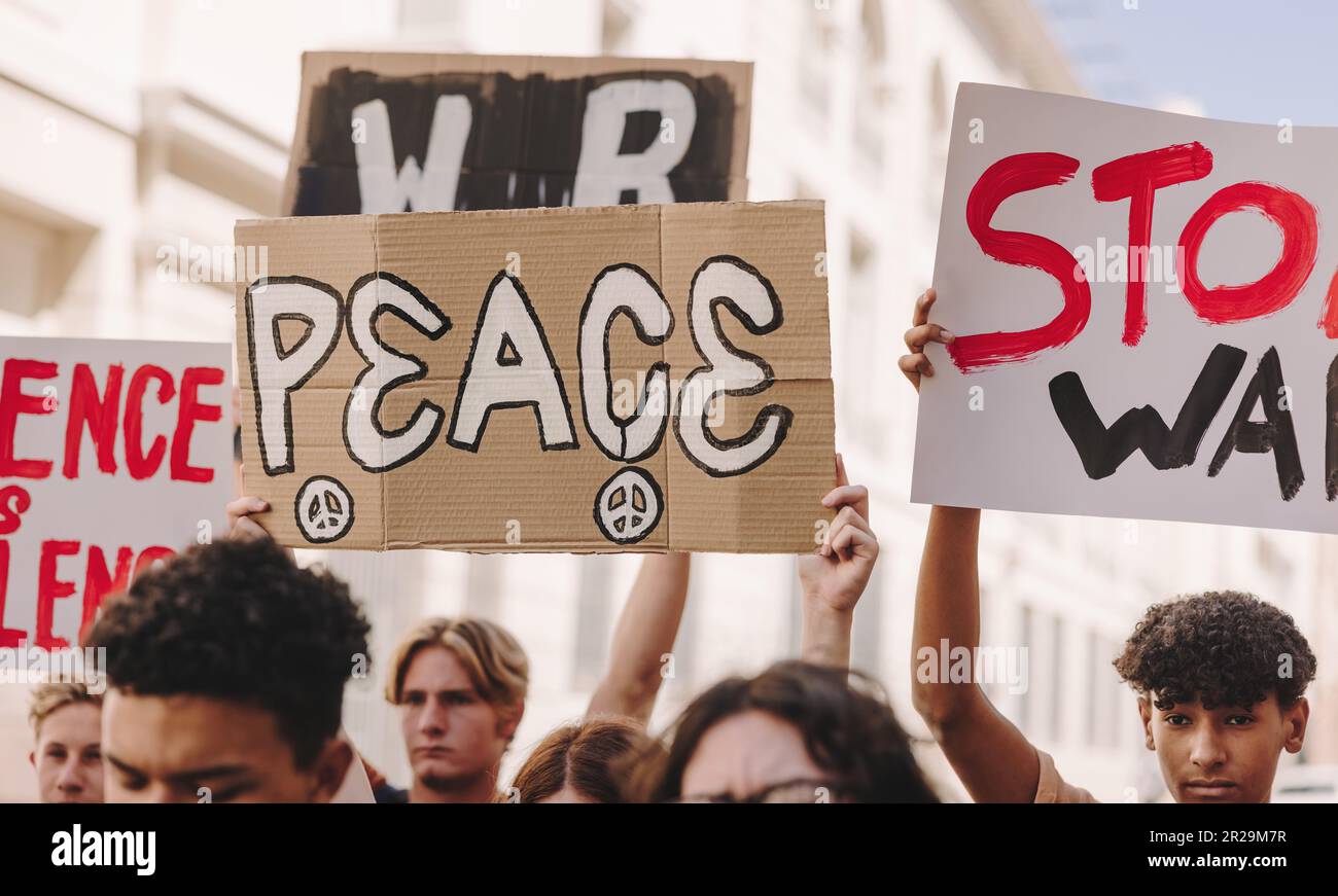 People marching in a peace protest holding signs against war