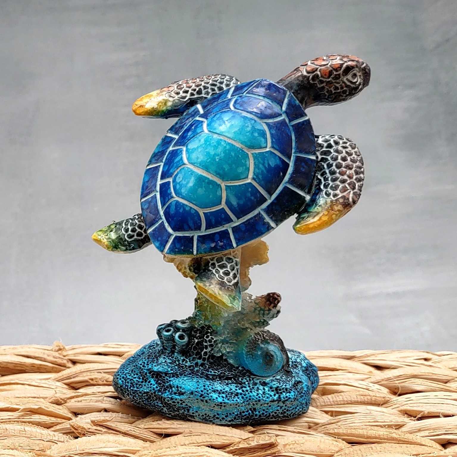 Blue green sea turtle figurine diving on coral base