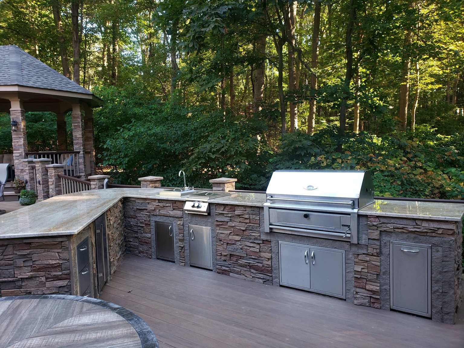 Outdoor kitchen island with built-in grill and stainless steel appliances