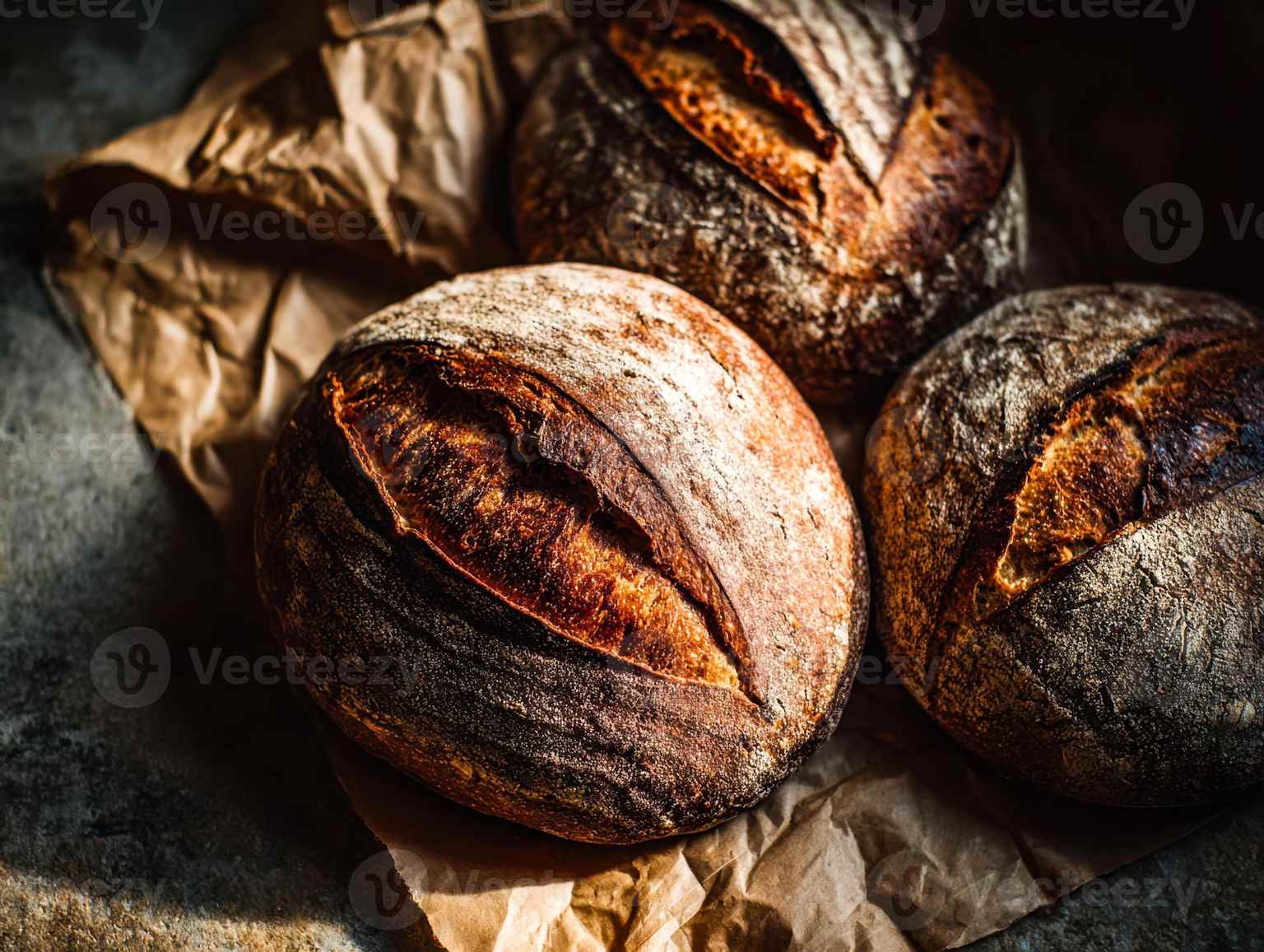 Three artisan sourdough loaves resting on parchment paper