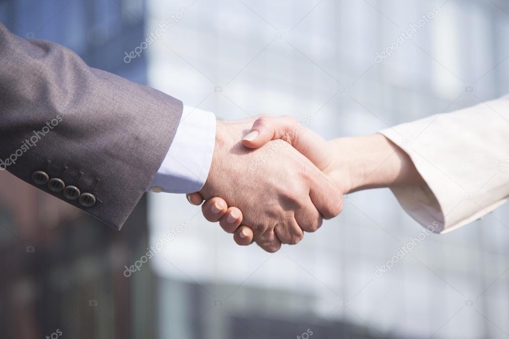 Geschäftsfrau und Geschäftsmann geben sich die Hand
