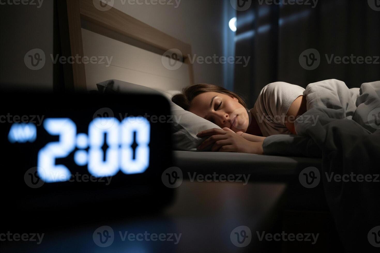 Woman sleeping peacefully in a dark bedroom at 2am, cycle-aligned bedtime calculator guide