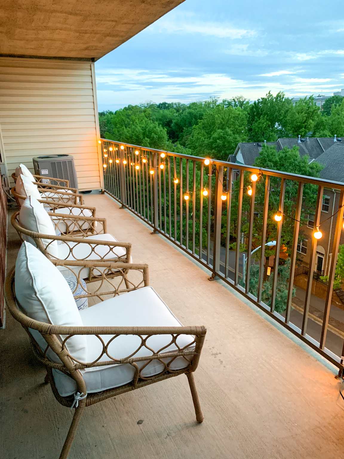Cozy apartment balcony decorated with warm string lights at dusk