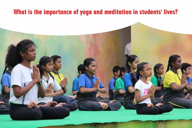 Group of Indian school students in uniforms practicing yoga meditation together in lotus pose with hands in namaste, indoors on yoga mats