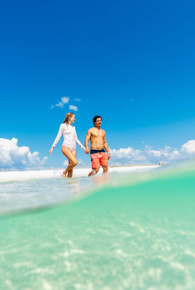 Couple walking on white sand beach Panama