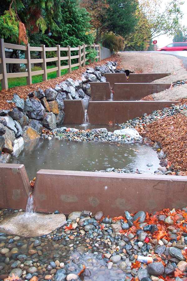 Urban stormwater channel with concrete weirs showing infrastructure challenges