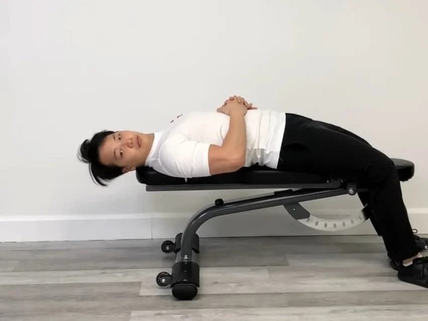 Exercício de chin tuck deitado: paciente realizando flexão cervical profunda no colchonete