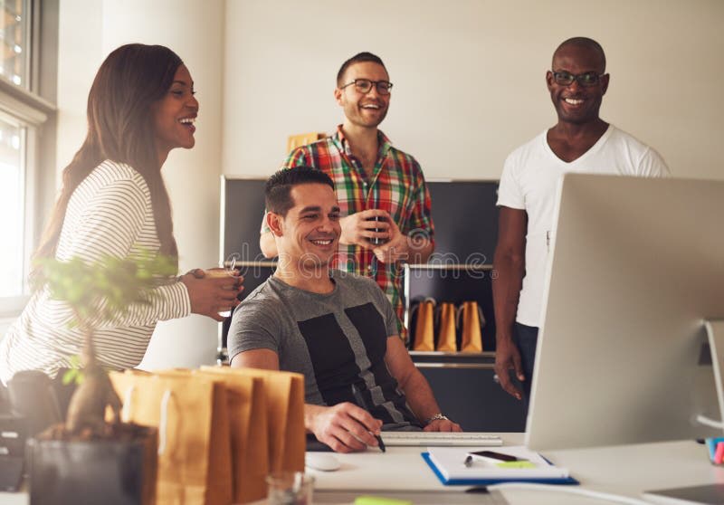 Diverse small business team collaborating around a laptop