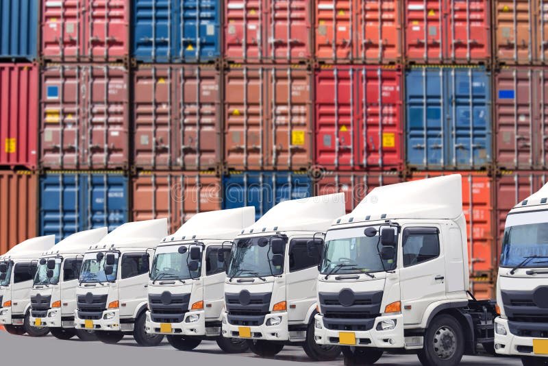 Camions garés devant des conteneurs sur un site logistique