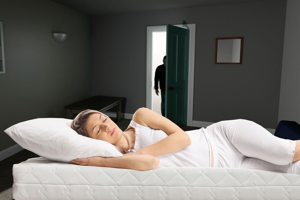 sleep paralysis causes — woman lying in bed unable to move during episode