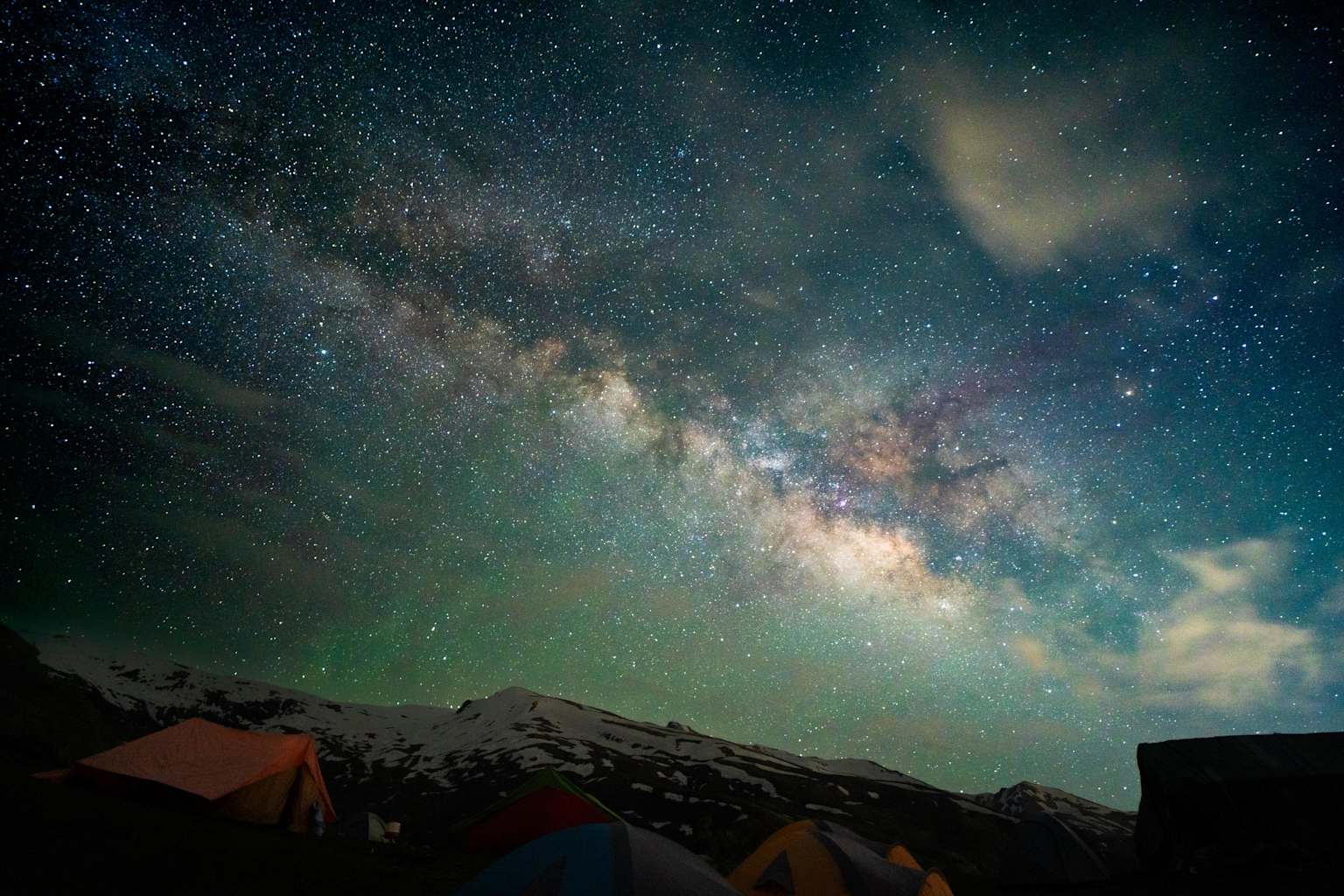 Milky Way over tents at an outdoor stargazing camp