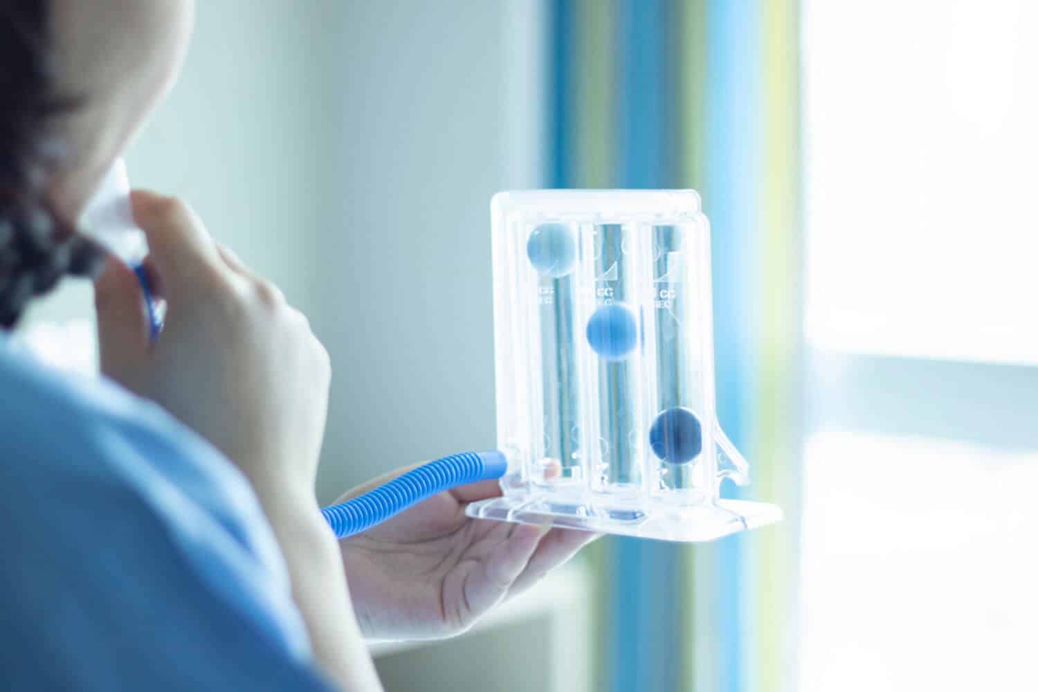 Profissional de saúde segurando espirômetro de incentivo — fisioterapia respiratória