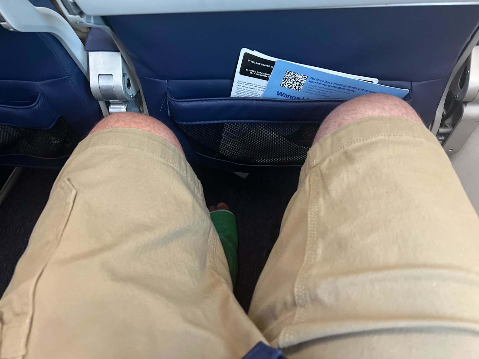 Knees pressed against airplane seat — 6 foot 1 and can't fit