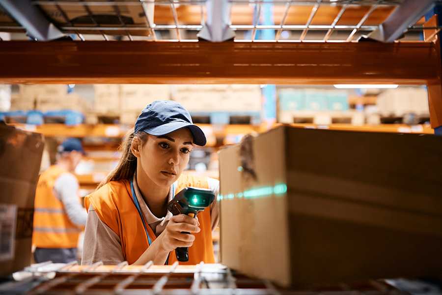 Collaborateur scannant un colis dans un entrepôt