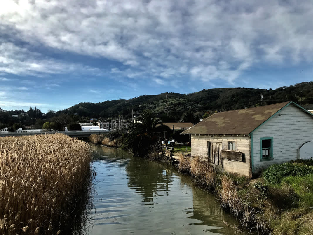Alhambra Creek, Martinez California — house beside creek with reeds and surrounding hills