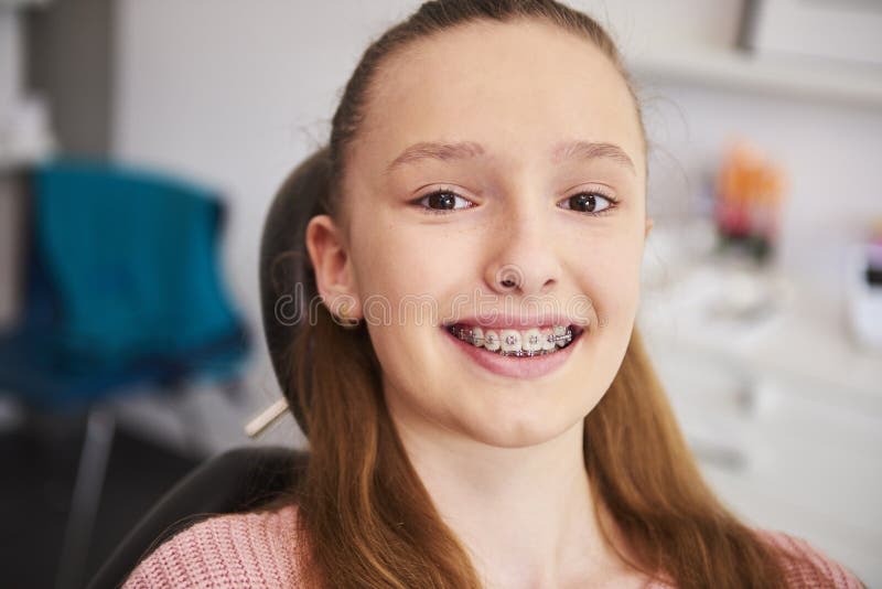Smiling child wearing braces in a dental office, happy and confident