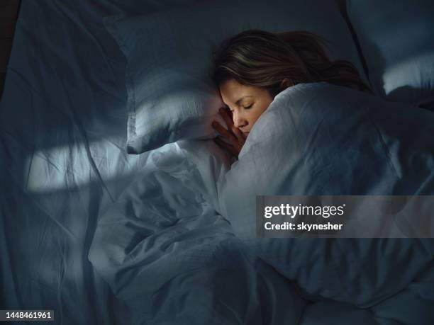 how many hours of sleep do you need — woman sleeping peacefully in bed at night