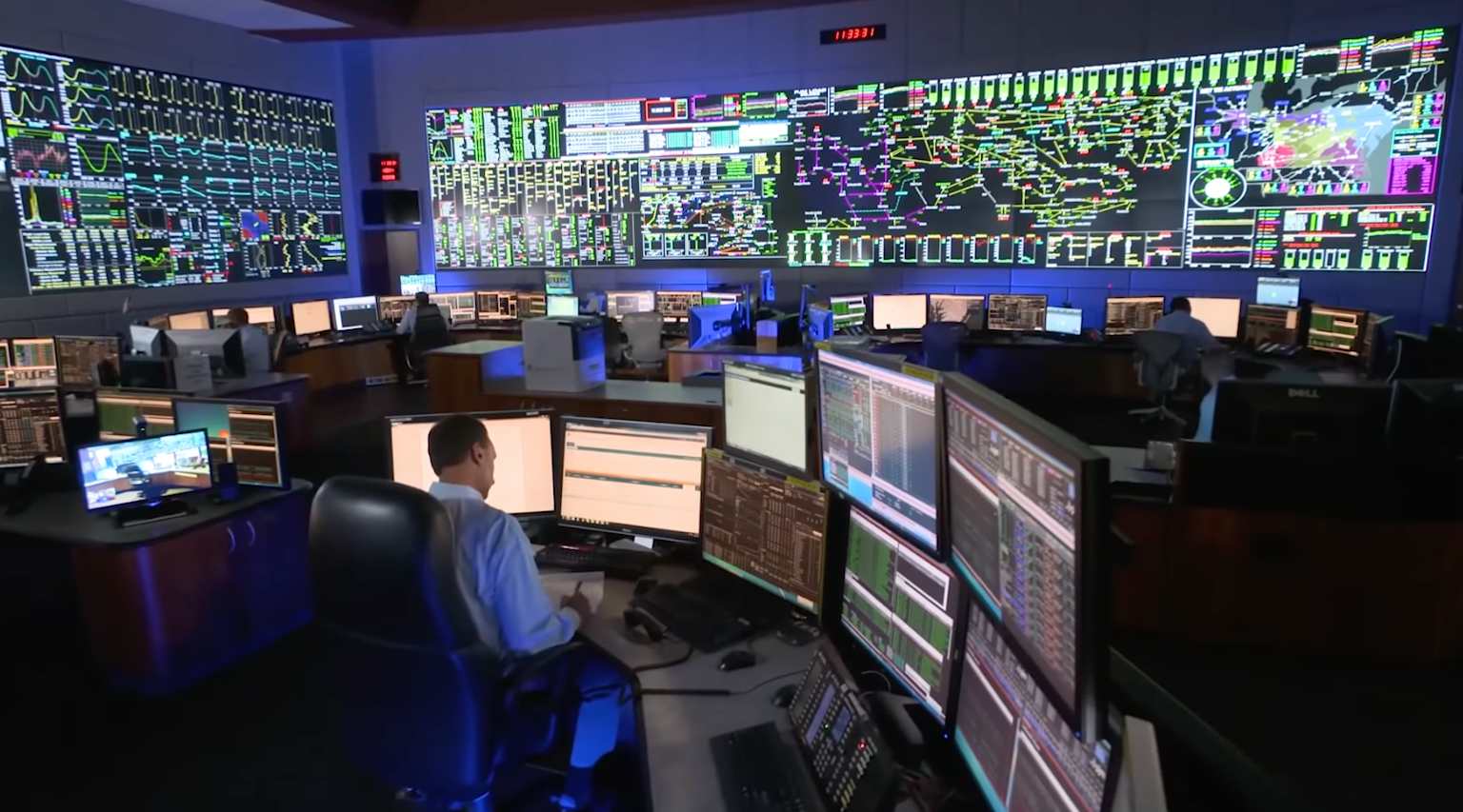 Utility grid control room with operators and large wall displays