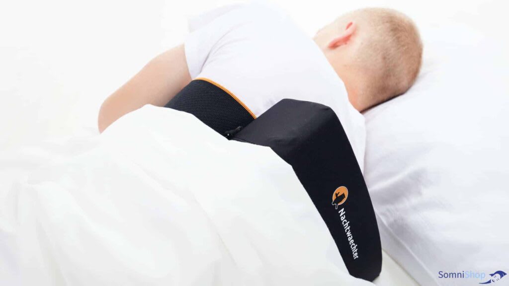 Sleep Apnea Without CPAP — 9 Treatments That Actually Work 11 Man wearing black neck brace positional therapy device for sleep apnea treatment in bed with white sheets