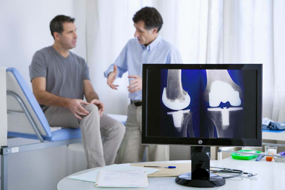 Orthopedic consultation with knee X-rays shown to a patient