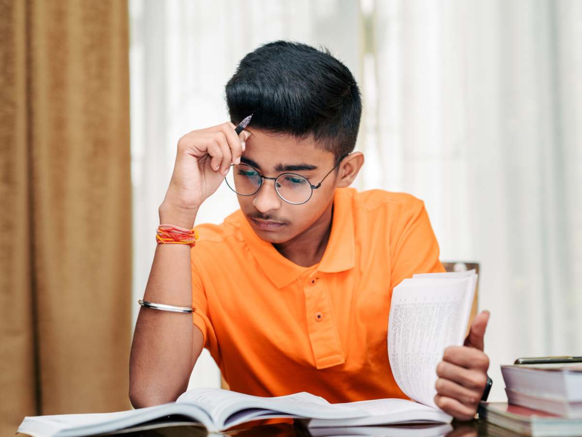 Student using active recall study technique with books and notes