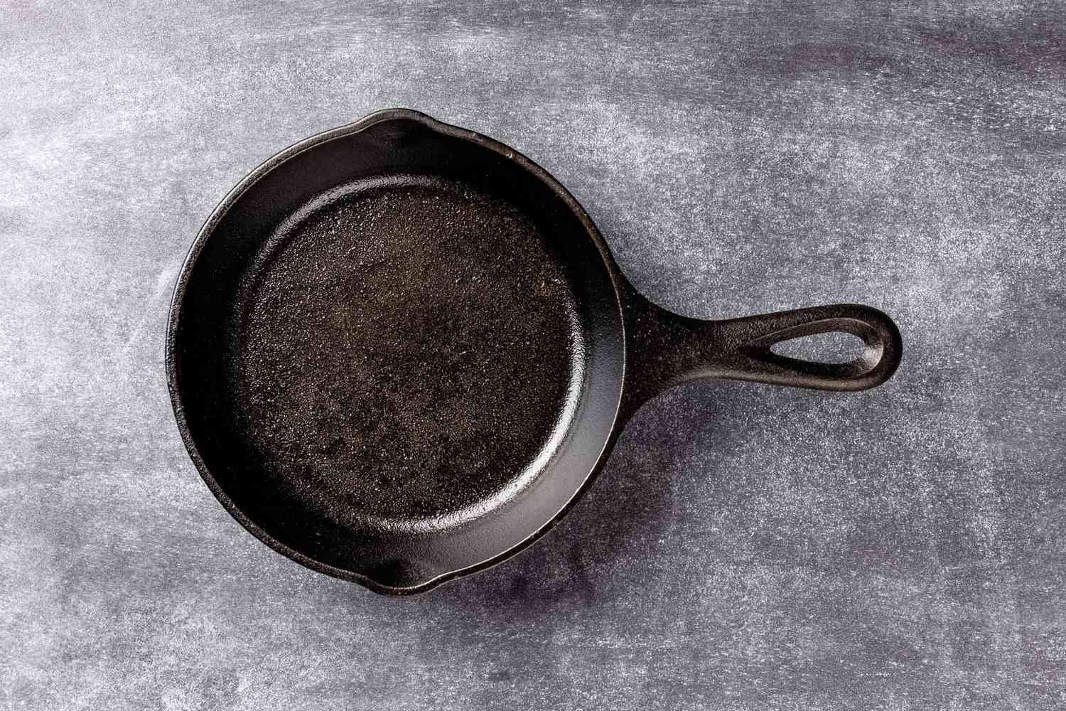Well-seasoned black cast iron skillet on kitchen surface