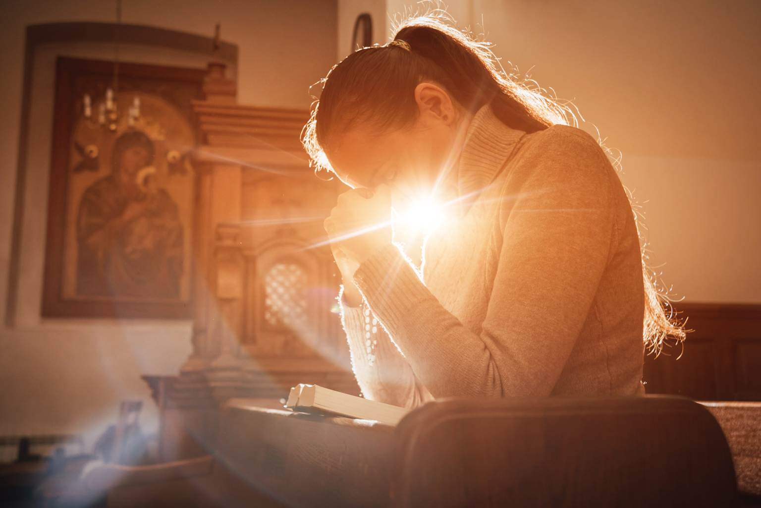 Woman praying in warm light