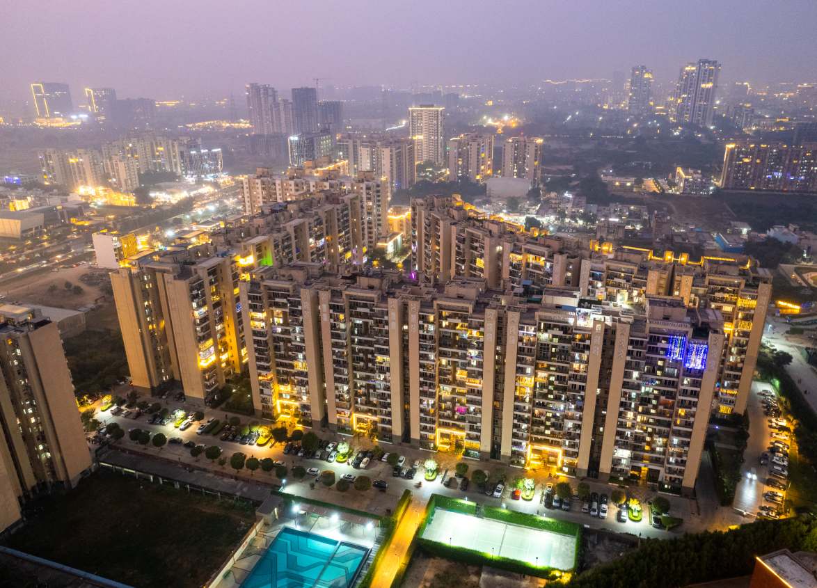 Large apartment development at night representing modern Hyderabad housing