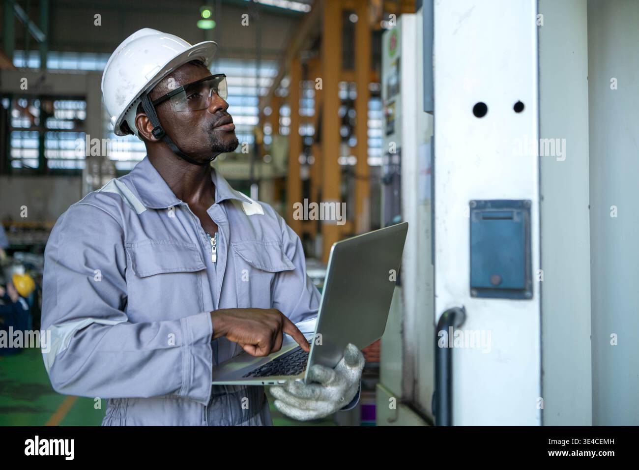 Technicien industriel utilisant un ordinateur portable en atelier