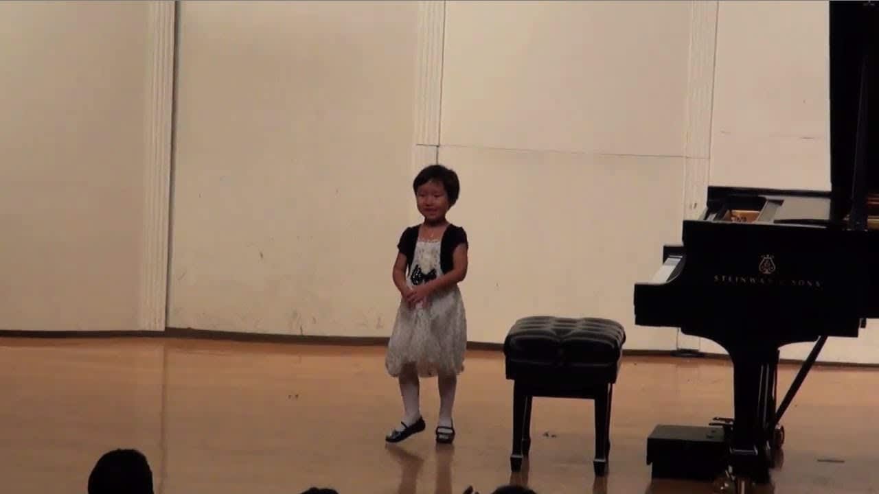 Child on stage at piano recital