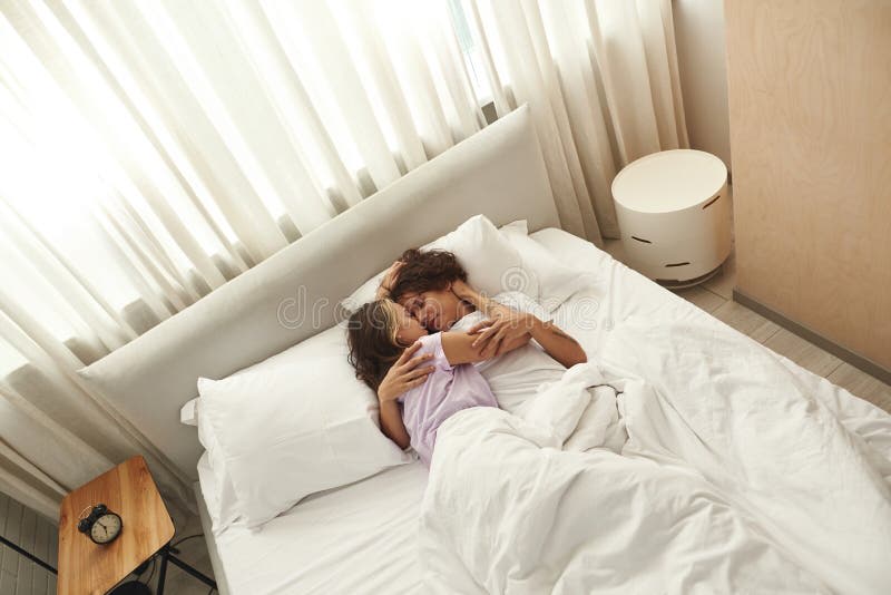 cuddling positions — couple face to face in bed smiling
