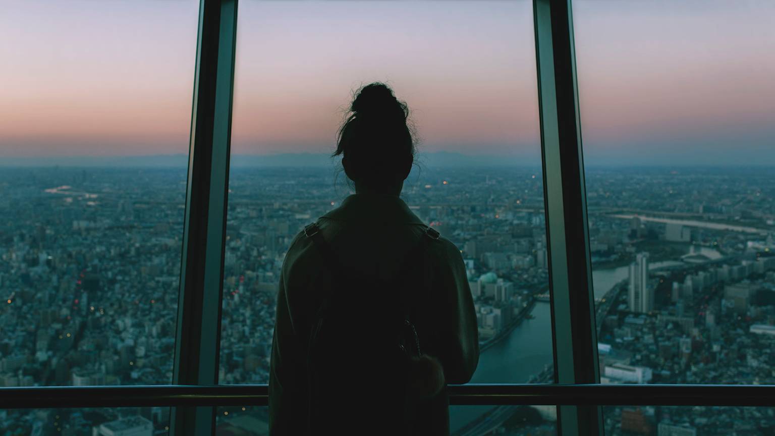 Pessoa contemplando a cidade ao entardecer — tema expatriado
