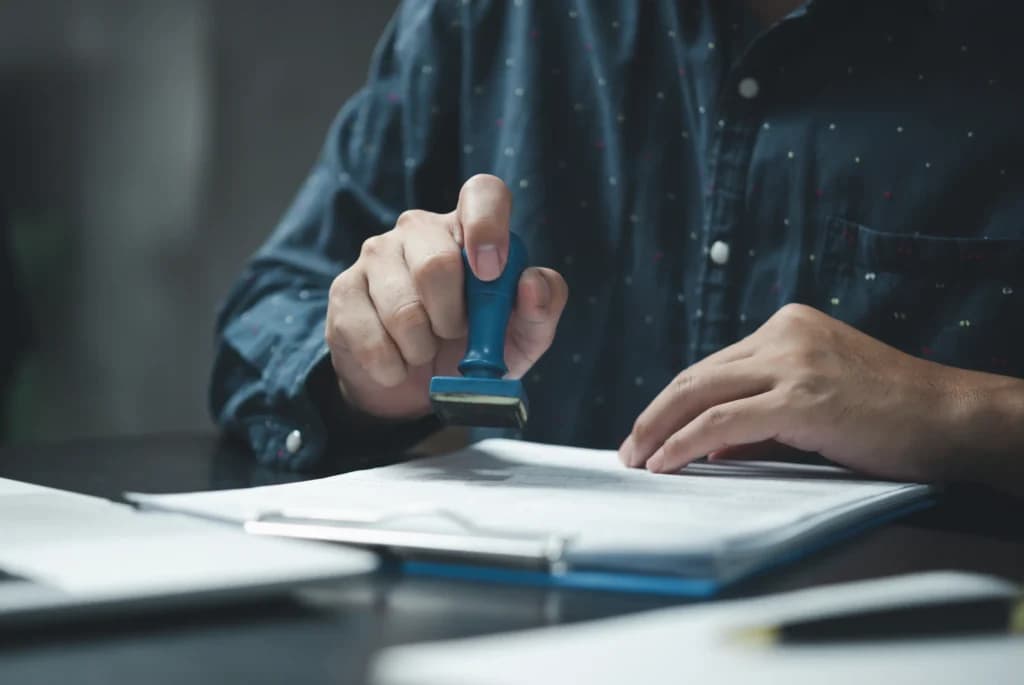 Людина ставить штамп на офіційний переклад документа