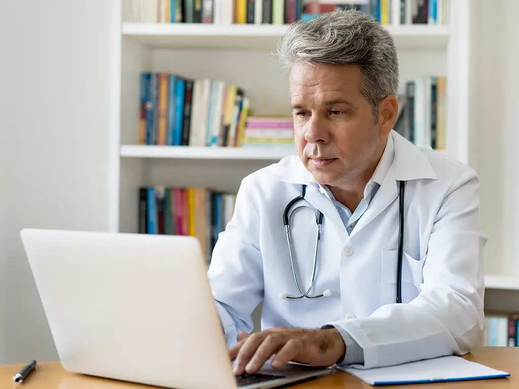 Lekarz z laptopem analizujący tekst medyczny