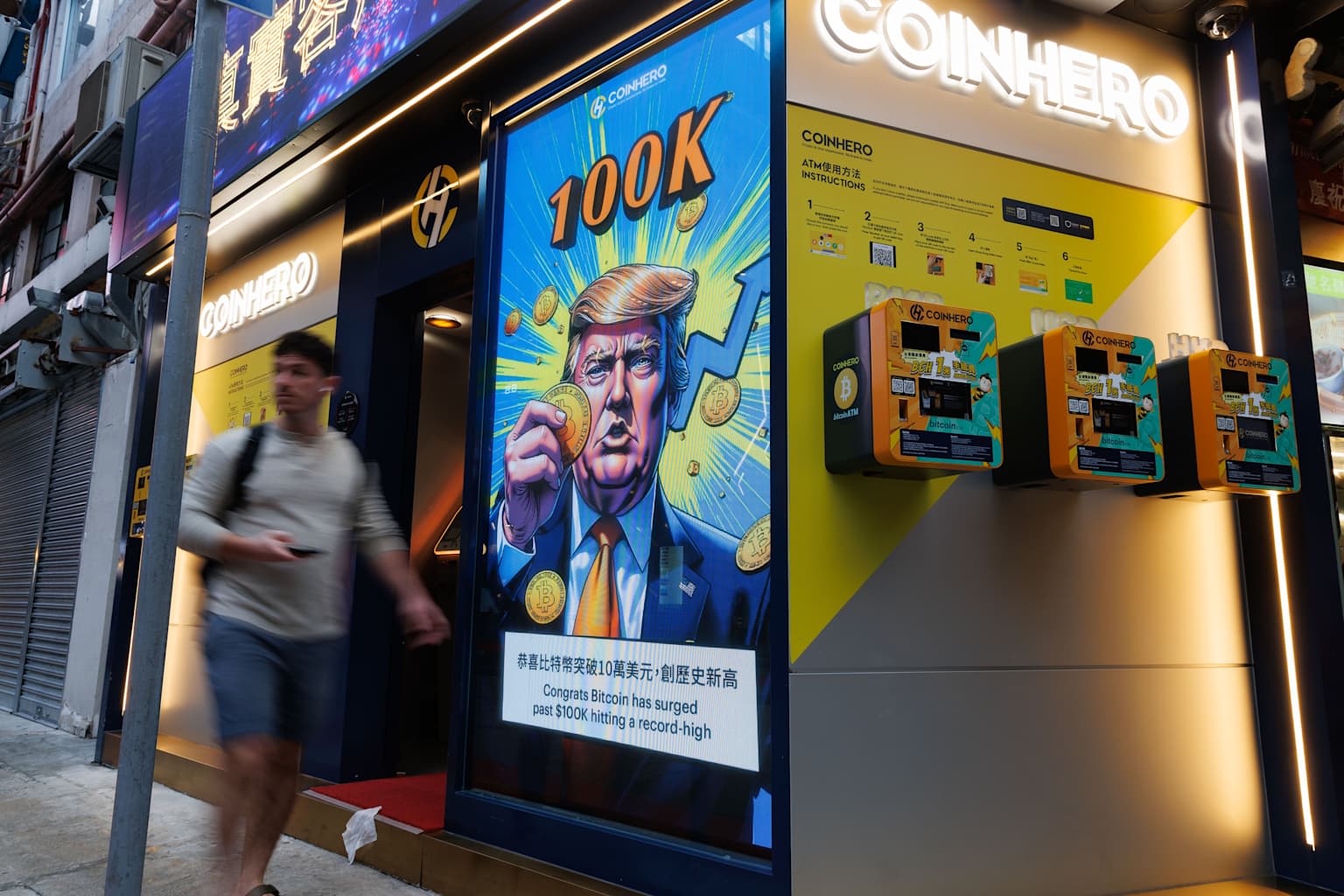 People walk past an advertisement feature Donald Trump with...