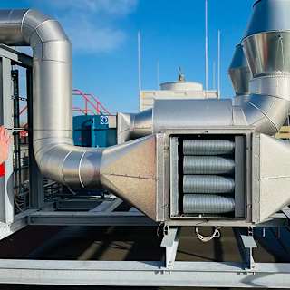 Industrial odor control system with metal ductwork installed on a rooftop for managing food processing plant emissions