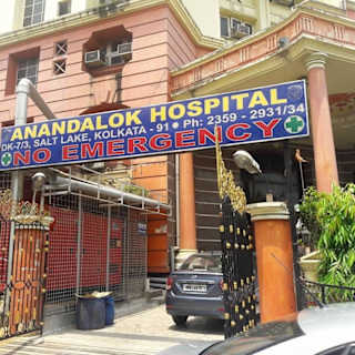 Entrance of Anandalok Hospital in Salt Lake, Kolkata, showing signboard with contact details and a notice of no emergency services