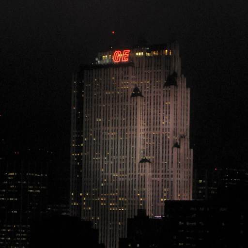 The GE Building (now Comcast Building) at 30 Rockefeller Plaza in New York City, photographed at night in 2005 showing the illuminated red "GE" logo.