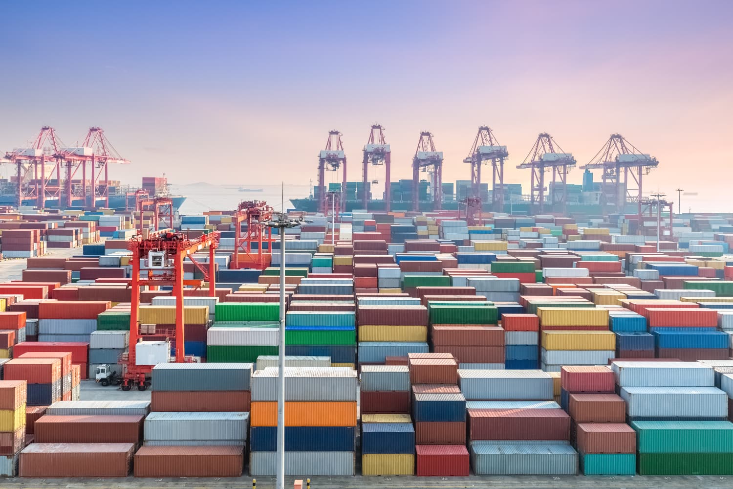 A busy international shipping port with numerous colorful containers and cranes, illustrating global trade and logistics