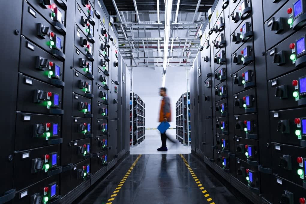 Modern data center infrastructure showcasing server racks and control panels, symbolizing investment in technology and AI growth sectors