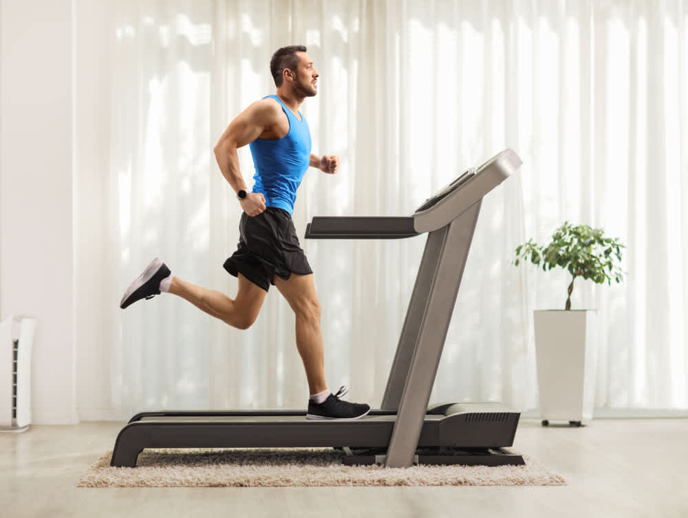 A man running on a treadmill, representing aerobic exercise for weight loss.