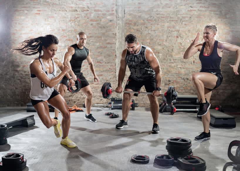 Group of people doing high-intensity interval training in a gym.
