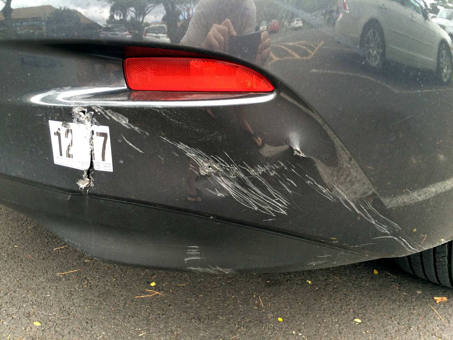Damage to a car bumper including scrapes and dents