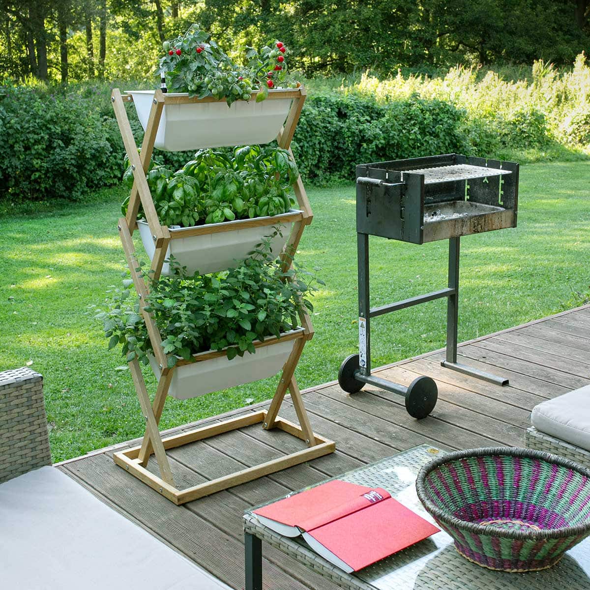 A vertical garden planter with multiple tiers of herbs and vegetables.