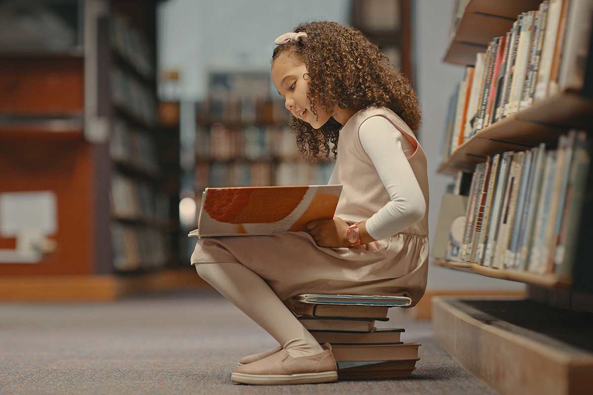 Jovem a ler na biblioteca escolar