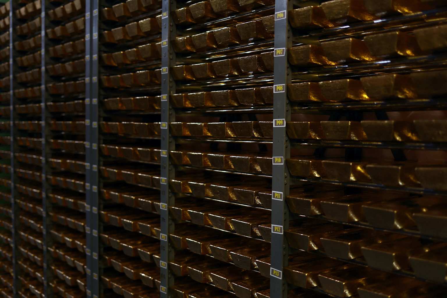 Gold bars meticulously stacked on shelves within a secure vault, indicative of central bank reserves