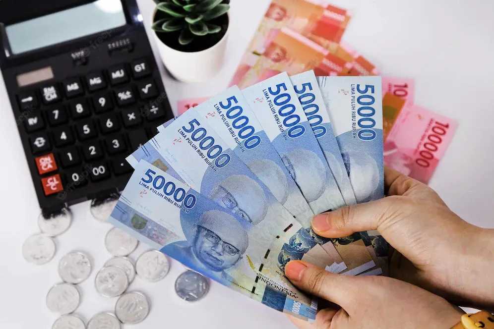 A Person Holding Indonesian Rupiah Banknotes.